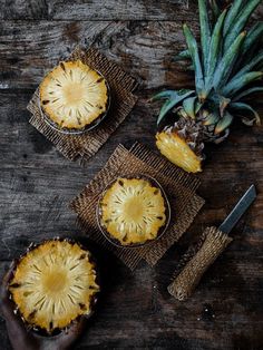 three pineapple pies sitting on top of a wooden table next to a knife