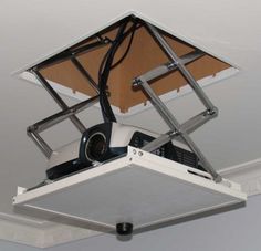 a ceiling mounted projector in the shape of a cube with wires attached to it