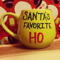 a yellow coffee mug with santa's favorite ho written on it