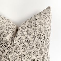 a black and white decorative pillow on a white wall with a light colored back ground