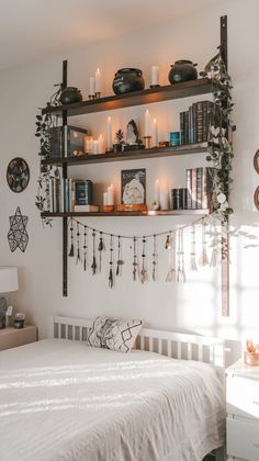 a white bed sitting under a shelf filled with candles