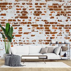 a white couch sitting in front of a brick wall