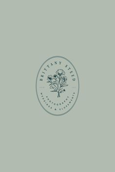 a white and blue logo for a flower shop on a gray background with the words,