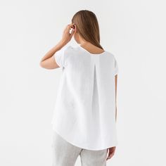 "Loose fit linen blouse TAHOE in white color is here to become your most loved piece for warm-weather outfits. Oversized, short sleeves, asymmetric hemline - our linen top has everything you need to feel chill & stylish. Perfectly suitable for summer escapes but equally works for an office look. Please note that actual colors may vary due to the many variations in monitors and browsers. DETAILS * Oversized silhouette * Short sleeves * Asymmetric hemline * True to size * Model is wearing size S a Everyday White Linen T-shirt, Relaxed White Blouse For Everyday, White Linen T-shirt For Everyday, Relaxed White Linen Top, White Linen Crew Neck Blouse, White Short Sleeve Blouse For Everyday, Everyday White Linen Top, Casual White Linen Blouse, Simple White Linen Top