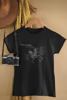 *Bay Laurel Wisdom Tee - Eco-Friendly, Recycled Materials* Embody the timeless wisdom of bay laurel with this inspired, eco-friendly tee. Made from 100% recycled materials, this comfortable shirt features an original botanical illustration of bay laurel, symbolizing honor, clarity, and mental focus This product is made especially for you as soon as you place an order, which is why it takes us a bit longer to deliver it to you. Making products on demand instead of in bulk helps reduce overproduct Botanical Tshirt, Recycled Ring, Bay Laurel, Illustration Botanique, Top Kitchen, Mental Focus, Kitchen Witch, Botanical Illustration, Unisex Design