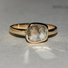 a close up of a ring with a stone in the middle on a gray surface