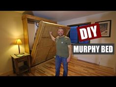 a man is standing in front of a bed that has been made out of wood