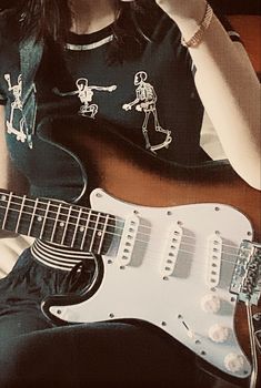 a woman sitting down with a guitar in front of her