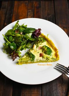 a piece of quiche with broccoli and other vegetables on a white plate