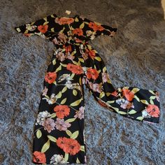 Size Small Petite Black Background Floral Jumpsuit/ Jumper. Tie Front, V Neck Line Down To The Tie. Black Short Sleeve Jumpsuits And Rompers For Vacation, Black Jumpsuits And Rompers For Spring Vacation, Black Short Sleeve Jumpsuit For Vacation, Urban Outfitters Jumpsuits And Rompers For Spring Day Out, Urban Outfitters Jumpsuits And Rompers For Beach In Spring, Black Floral Print Jumpsuits And Rompers For Vacation, Urban Outfitters Beach Jumpsuits And Rompers For Spring, Casual Black Floral Jumpsuits And Rompers, Black Floral Print Jumpsuit For Vacation