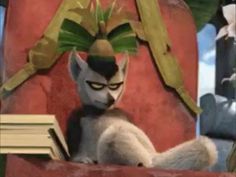 the animated cat is reading a book while sitting in a chair