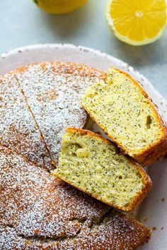 lemon poppy seed cake with powdered sugar on the top, sliced and served on a white plate