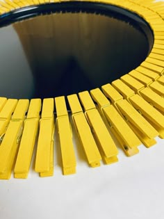 a mirror that is yellow and black with some sticks sticking out of the top of it