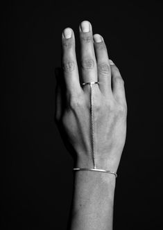 black and white photograph of a person's hand with a bracelet on their wrist