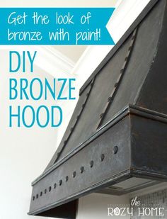 the diy bronze hood has been painted black and is next to a white wall