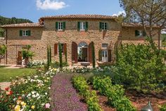 a large house with lots of flowers in the front yard