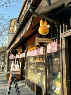 a store front with stuffed animals hanging from it's windows and decorations on the outside