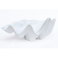 a white sculpture with wavy shapes on it's sides, sitting in front of a white background