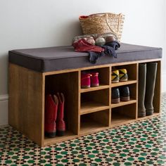 a wooden bench with several pairs of boots on it and a basket over the top