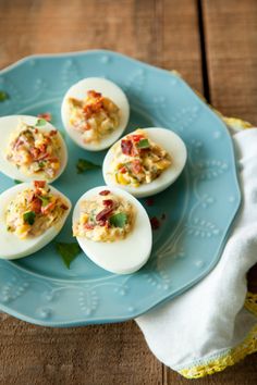 four deviled eggs on a blue plate