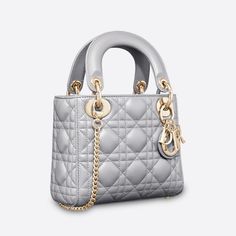 The Lady Dior handbag epitomizes the House's vision of elegance and beauty. Refined and sleek, this creation is timeless. Crafted in opaline pearlescent lambskin with Cannage stitching, it boasts an instantly recognizable quilted texture. The pale gold-finish metal D.I.O.R. charms embellish and illuminate its silhouette. Featuring a removable chain shoulder strap, the miniature Lady Dior bag can be carried by hand or crossbody as an ideal evening wear companion. Removable chain strap Interior zip pocket The bag may be paired with different embroidered straps Dust bag included Made in ItalyCOMPOSITIONLambskinProduct code:M0505OADU_M11GSIZE GUIDE WIDTH×HEIGHT×DEPTH：17 x 15 x 7 cm Dior Mini Bag, Lady Dior Mini, Mini Lady Dior, Lady Dior Handbag, Bag With Chain, Statement Bag, Dior Handbags, The Lady, Lady Dior Bag