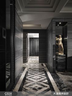 an elegant hallway with black and white marble flooring, gold statue in the doorway