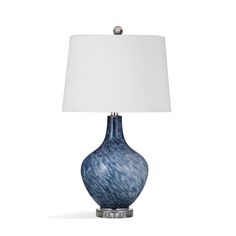 a blue and white lamp with a white shade on it's base, against a white background