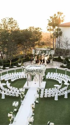 an outdoor ceremony setup with white chairs and flowers