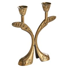 two golden candlesticks are sitting side by side on a white background, one is shaped like a tree