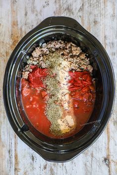 a crock pot filled with meat and spices