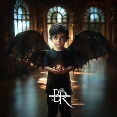 a young boy is holding a ring in his hands while wearing a black shirt and wings