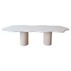 a white table with two legs and a large slab on the top that is shaped like a wave