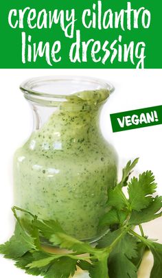 a jar filled with green cilantro dressing on top of a table