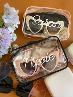 two personalized sunglasses are sitting on a table next to some flowers and other items