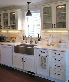 a kitchen with white cabinets and wooden floors