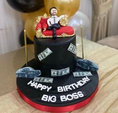 a birthday cake decorated with money and a man sitting on top of a red chair