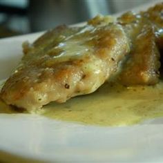 a white plate topped with meat covered in gravy