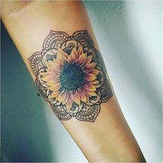 a sunflower tattoo on the arm with an intricate pattern and flower in the center