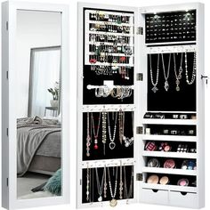 a white mirrored closet with jewelry hanging on the door and mirror in front of it