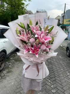 a woman holding a bouquet of pink flowers