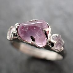 pink sapphire (home tumbled). I hand carved this setting in wax and cast it in recycled solid 14k white gold using the lost wax casting process. This one-of-a-kind gemstone ring is a size 7 it can be resized up or down for you as needed. The sapphire stone measures about 7.5x6.5mm. The side sapphires are around 4.5mm. The band is about 3mm wide Throughout all time and history in every tribe and culture all around the world crystals, minerals and gemstones have been used for healing, luck, divina Pink Gem Ring, Pink Stone Ring, Raw Gemstone Jewelry, Gold Solitaire Ring, Pink Gem, Gemstone Engagement, Wax Casting, Gem Ring, Minerals And Gemstones