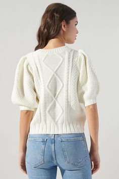 Stay cozy in this cable knit sweater top. Features a classic round neck that tops a knitted bodice framed by short puff sleeves. It maintains a classic fit with a ribbed sweep. Keep it simple by pairing it with wide leg trousers and boots.- Cable knit- Classic fit- Ribbed sweep- Puff sleeve- Comes in 2 colorsSize + Fit - Model is 5'8" and wearing size XS- Measurements taken from size S - Chest: 37 1/2"- Length: 18 1/2" Fabric Self: 55% Nylon, 45% Acrylic Style Number STT16449 Crew Neck Cable Knit Top, Cable Knit Crew Neck Top, White Cable Knit Short Sleeve Top, White Short Sleeve Cable Knit Top, Chic Short Sleeve Cable Knit Tops, Trendy Crew Neck Cable Knit Top, Trendy Cable Knit Crew Neck Top, Fall Cable Knit Short Sleeve Tops, Cable Knit Short Sleeve Top