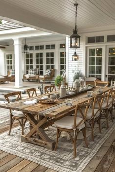 a wooden table sitting on top of a wooden floor next to a white house with lots of windows