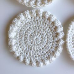 three crocheted coasters sitting on top of a table