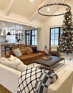 a living room filled with furniture and a christmas tree in the middle of the room