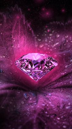 a pink diamond surrounded by water droplets on a purple surface with stars in the background