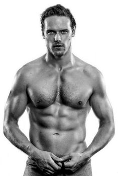 a shirtless man with no shirt on posing for a black and white photo, his hands in his pockets