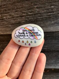 someone is holding a rock that says, you can't make a rainbow without a little rain