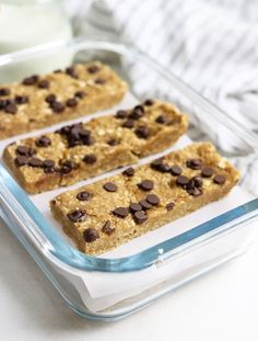 chocolate chip granola bars in a glass baking dish on a white counter with milk