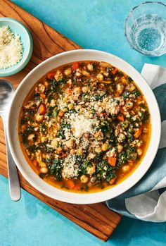 a bowl of soup with spinach, chickpeas and parmesan cheese